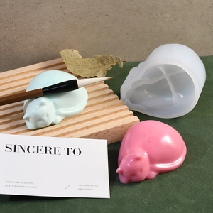 Macro detail of cat-shaped silicone mold and finished resin sleeping cat pen holders