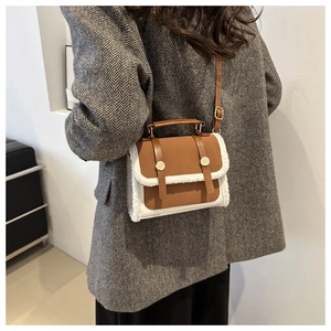 Detail view of vintage dark brown and beige crossbody bag with plush wool trim and gold hardware