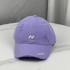 Macro view of purple baseball cap with distressed torn details and white 3D embroidery
