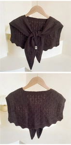 Detail of dark brown knitted shawl with hollow diamond patterns and delicate lace-up design
