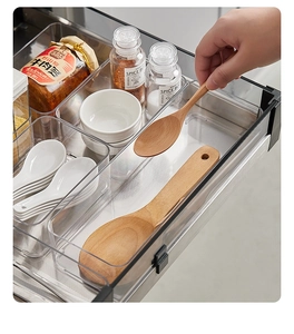 Macro detail of transparent drawer organizers showing various sizes for cutlery storage