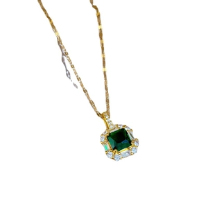 Elegant gold titanium necklace featuring an emerald pendant surrounded by zircons