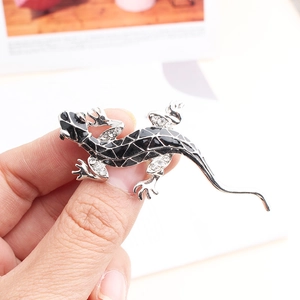 Detail of lizard brooch with black enamel, white crystals, and silver-plated finish