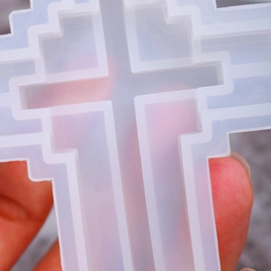 Close-up of translucent silicone cross mold showing multi-layered step structure for DIY crafts