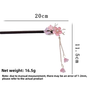 Detail view of wooden hair stick with pink flower, butterfly, and 11.5cm tassels