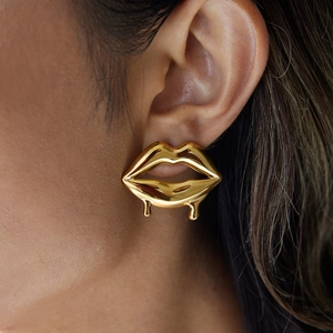 Detail einer Frau mit vergoldeten Lippen-Ohrringen und flüssigem Tropfendesign