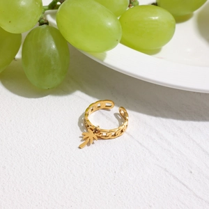 Dettaglio anello in acciaio placcato oro 18K con ciondolo a palma e design a catena