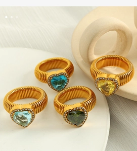 Detail view of colorful heart-shaped crystal rings in gold plating with pavé stones