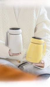 Close-up of portable mini mushroom vacuum flasks in white and yellow with carry handle