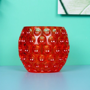 Macro detail of red translucent glass candle holder with embossed dot texture