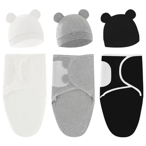 Detailed view of soft cotton baby swaddle blankets and bear ear hats in white, grey, and black