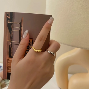 Minimalist geometric wavy ring set in gold and silver finish on model hand