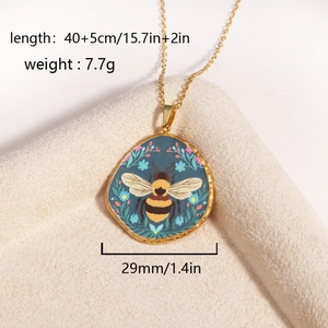Detailed view of bee pendant necklace with blue floral art and size specifications