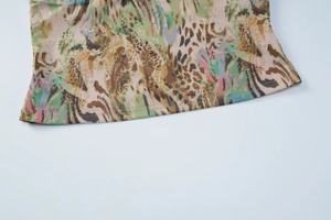 Detailed close-up of leopard print hem with intricate stitching on a lace camisole