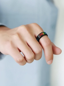 Detail of black stainless steel pride ring with rainbow lettering on male hand