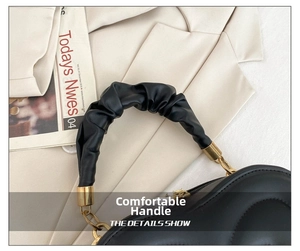 Detail der gesteppten Herz-Box-Tasche mit gerüschtem Griff und goldenen Kettendetails