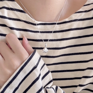 Close-up of 925 sterling silver bud pendant with vertical texture on a collarbone chain