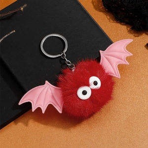 Détail d'un porte-clés chauve-souris en peluche rouge avec ailes et yeux mignons
