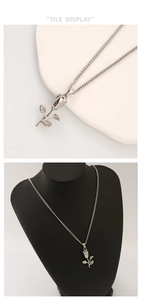 Detail display of silver rose pendant necklace shown on tray and jewelry mannequin stand