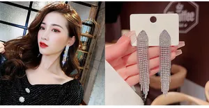 Macro detail of long silver tassel earrings with rhinestones and elegant fringe design