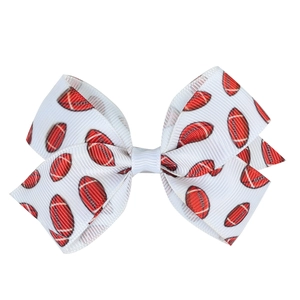 Detail of white grosgrain ribbon hair bow with printed red American football pattern