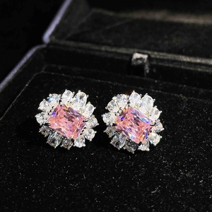 Close-up of pink rectangular stud earrings with white gemstones in a black velvet box