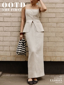 Detail of minimalist beige cotton linen two-piece set with button vest and long slit skirt