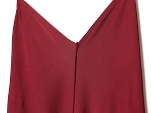 Detailed close-up of the smooth red satin fabric and V-neck stitching on the dress