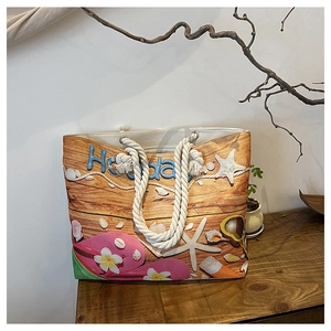 Detail of beach themed canvas tote bag with nautical shell patterns and holiday text