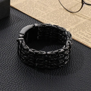 Close-up of black 316L stainless steel Byzantine bracelet on textured leather background