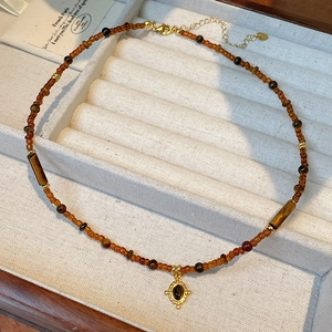 Detail of 18k gold plated tiger eye beaded necklace with oval gemstone pendant