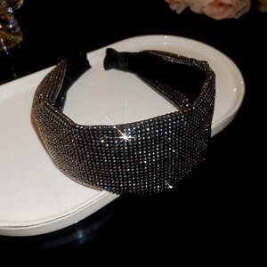 Close-up of luxury wide headband with shimmering silver crystals on a black base