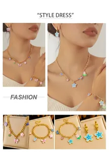 Détails d'un ensemble de bijoux dorés avec pendentifs colorés en émail papillon et fleurs