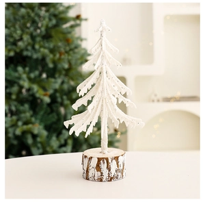 Close-up of a mini snowy Christmas tree with realistic snow-covered branches and wooden base