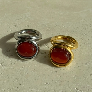 Detailed macro shot of vintage liquid gold and silver rings with oval red agate stones