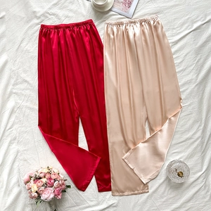 Ensemble de pantalons de pyjama en satin rouge et champagne sur fond minimaliste