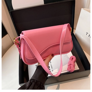 Pink leather saddle bag in a gift box with dual straps and classic curved flap design