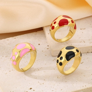 Minimalist gold stainless steel rings with colorful enamel dots on textured stone