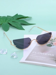 Cat eye sunglasses with warm gold metal frame and gradient lenses on a magazine background