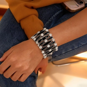 Dettaglio di un bracciale elastico largo con pietre nere e strass brillanti incastonati