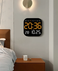 Modern black LED wall clock showing time, date and temperature in a bedroom setting
