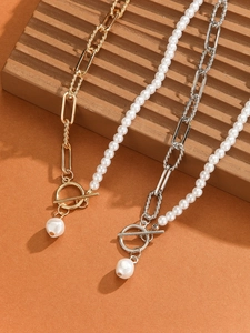 Detail of gold and silver half-pearl paperclip chain necklaces with pearl OT buckle