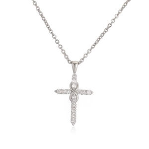 Gros plan d'un collier pendentif croix en argent serti de zircons sur chaîne fine