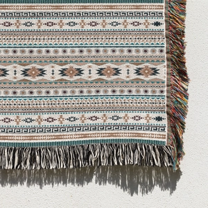 Close-up of bohemian woven blanket with geometric patterns and colorful tassels