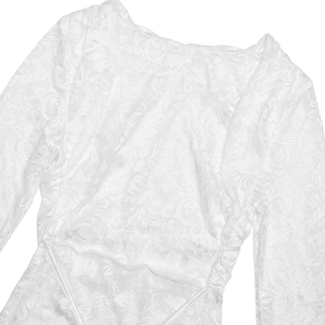 Close-up of white floral lace fabric showing intricate texture and weave patterns