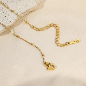 Detail of gold-plated stainless steel necklace with lobster clasp and pearl accents
