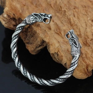 Detail eines Wikinger Drachenarmbands mit gedrehtem Edelstahlseil-Design auf Holz