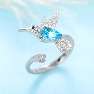 Macro-opname van de kolibrie-ring met een peervormige blauwe steen en witte zirkonia