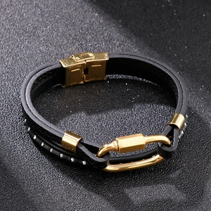 Detailed close-up of a braided black leather bracelet with a gold stainless steel clasp