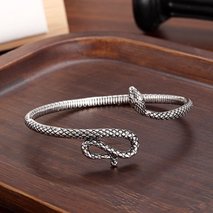 Silver snake-shaped open cuff bracelet with textured scales and detailed serpent head design